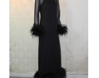May include: A black maxi dress with long sheer sleeves and a black feather trim around the cuffs and hem.