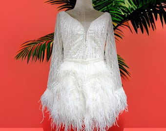 Vestido de novia MARAYA blanco con pedrería, manga larga y minivestido de plumas de avestruz.