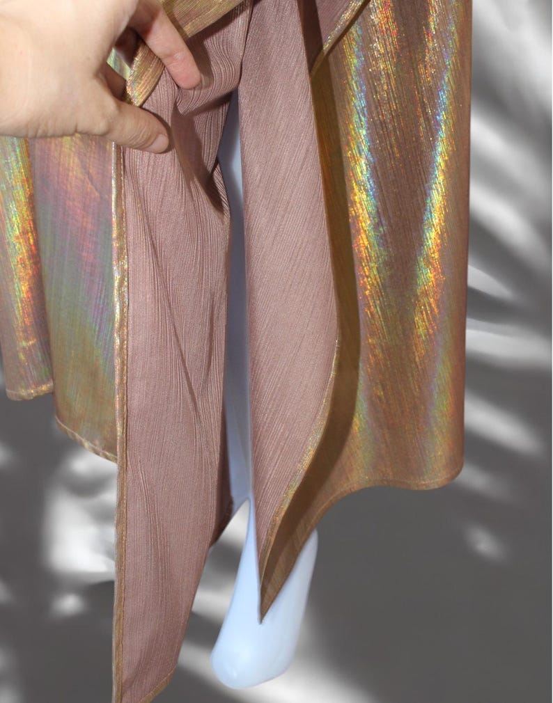 May include: A gold iridescent fabric with a pink lining. The fabric has a subtle sheen and a textured surface.