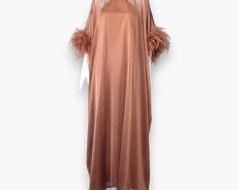 May include: A long, flowing, rust-colored satin dress with sheer sleeves and feather trim.