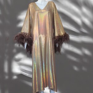 May include: A long, gold iridescent dress with brown feather trim on the sleeves.