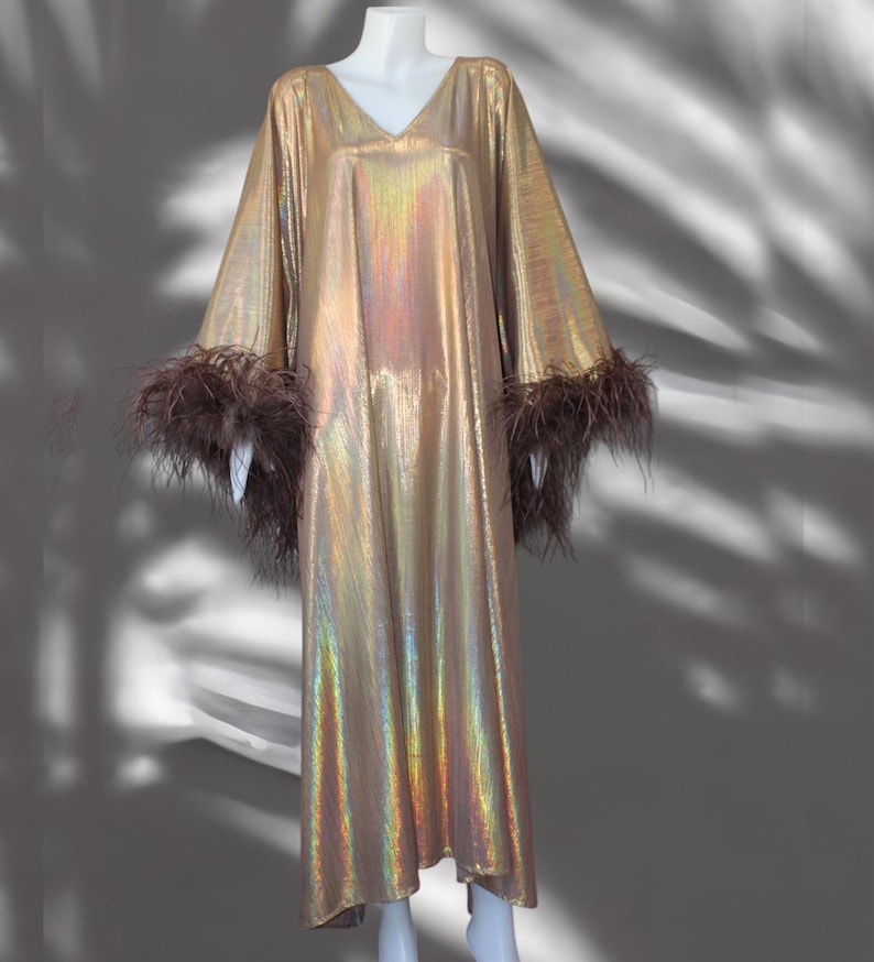 May include: A long, gold iridescent dress with brown feather trim on the sleeves.