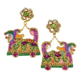 May include: A pair of gold tone earrings featuring a colorful beaded design of a Mardi Gras float with a jester face. The earrings are accented with clear and green rhinestones.