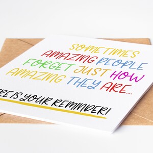 May include: A white card with the text "Sometimes amazing people forget just how amazing they are... This is your reminder!" in colorful lettering.