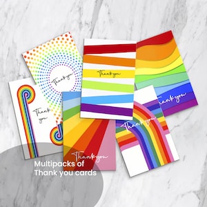 May include: A collection of colorful thank you cards with rainbow designs. Each card features the words "Thank you" in a handwritten style. The cards have various patterns, including stripes, dots, and rainbow arches. The text "Multipacks of Thank you cards" is also visible.
