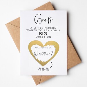 Pu&ograve; includere: Un biglietto bianco con dettagli dorati. Il biglietto dice "Geoff, Una piccola persona vuole farti una grande domanda. Vuoi essere il mio padrino?" con una forma di cuore in lamina dorata che puoi grattare per rivelare la domanda.