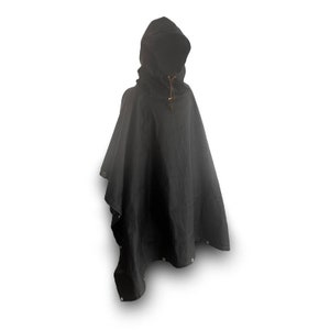 May include: A black hooded poncho with a drawstring closure at the neck. The poncho is made of a water-resistant fabric and has a relaxed fit.