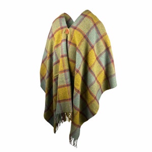 May include: A green, yellow, and red plaid poncho with a wooden button.