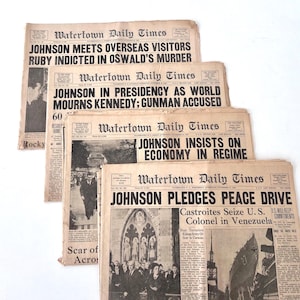 Peut inclure: Quatre journaux anciens du Watertown Daily Times. Les titres incluent "JOHNSON MEETS OVERSEAS VISITORS", "JOHNSON IN PRESIDENCY" et "JOHNSON PLEDGES PEACE DRIVE". Les journaux sont jaunis, affichant des nouvelles historiques.