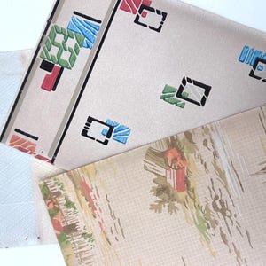 May include: A collection of vintage wallpaper samples. One sample features a geometric design with black, red, blue, and green shapes on a cream background. Another has a landscape scene with red and green accents.