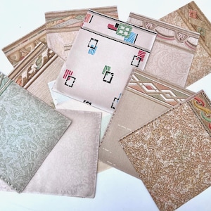 May include: A collection of vintage wallpaper samples in various patterns and colors. The samples include geometric, floral, and abstract designs with a mix of pastel and earthy tones. Some samples have decorative borders.