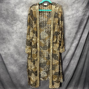 May include: A long-sleeved, open-front duster cardigan featuring a dark brown and gold animal print pattern. The garment is embellished with vertical rows of gold sequins along the front placket and cuffs, creating a shimmering, textured appearance.