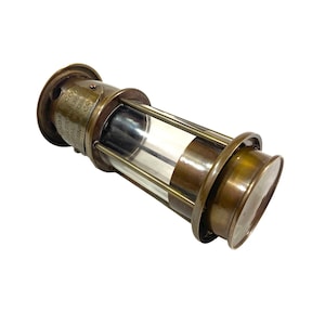 May include: A brass miner's lamp with a clear glass cylinder and a label that reads "INDIA COAL MINING CO. LTD. CALCUTTA.  APPLY FOR PERMISSION TO USE THIS LAMP.  ECO7", a vintage collectible.