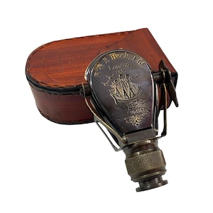 Peut inclure: Longue-vue antique en laiton et noir avec un étui en cuir. La longue-vue est gravée d'un voilier, du texte "R. & J. Beck, London 1857" et du numéro de série 964387. L'étui en cuir est marron.