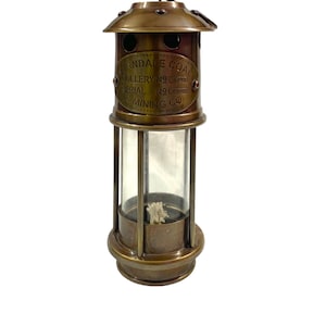 May include: Brass miner's lamp with a glass cylinder and a label that reads "Erndale Coal Colliery No. 3721 Serial No. 2900 & Mining Co."