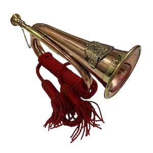 May include: A brass bugle with a red tassel and a gold eagle emblem. The bugle has a long, curved mouthpiece and a bell at the end. The tassel is attached to the bugle with a cord.