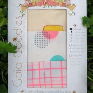 May include: A package of Gaia Goodies beeswax bags. The package includes bags with pink and grey geometric patterns. The text on the package says "Beeswax bags - bagged by bees". The bags come in various sizes, from 20cm x 24cm to 40cm x 30cm.