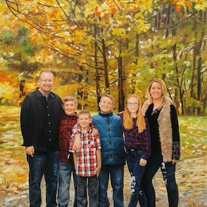 May include: A family portrait of six people standing in a forest setting. The family is dressed in casual clothing and is smiling. The background is a colorful autumn forest with yellow, orange, and red leaves. The year 2021 is written in the bottom right corner of the image.
