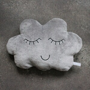 May include: A gray plush cloud-shaped pillow with embroidered eyes and a smiling mouth.
