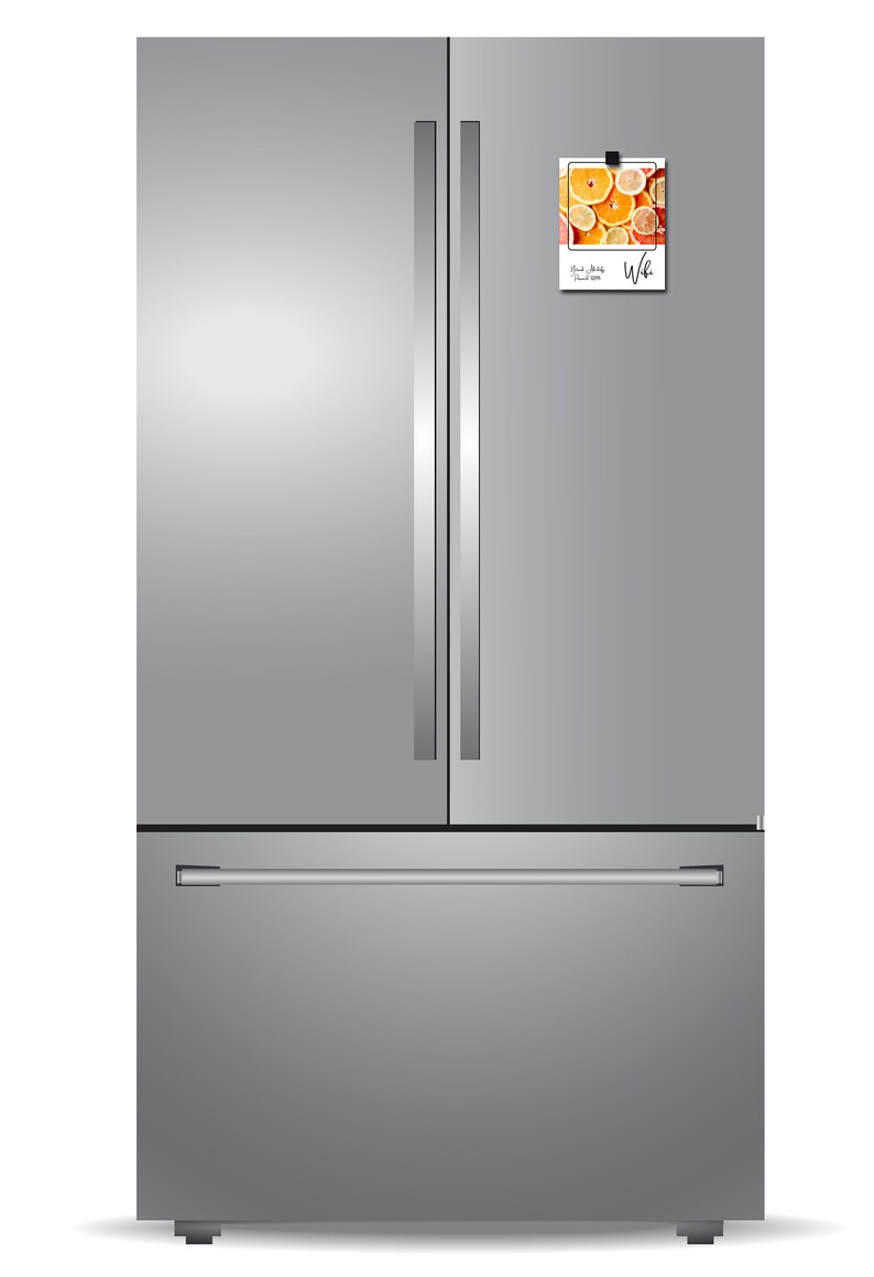 Pode incluir: Um refrigerador de a&ccedil;o inoxid&aacute;vel com portas francesas e uma gaveta de congelador abaixo. Um &iacute;m&atilde; com uma imagem de frutas c&iacute;tricas e o texto "Fruit Salad" est&aacute; preso &agrave; porta direita.