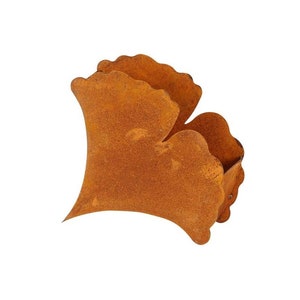 Könnte beinhalten: Ein rostiger Metalltopf in Form eines Ginkgoblattes. Der Topf ist tief orange-braun und hat eine leicht strukturierte Oberfläche.