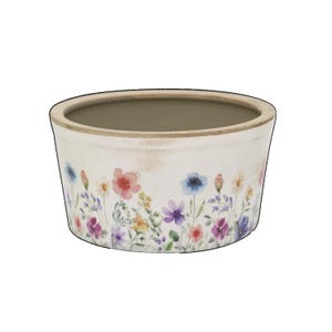 Könnte beinhalten: Eine runde, cremeweiße Keramikschale mit einem Blumenmuster im Aquarellstil auf der Außenseite. Das Design zeigt verschiedene kleine Blumen in Rosa-, Blau-, Lila- und Gelbtönen mit grünen Stielen. Der Rand ist in einem natürlichen Beigeton gehalten.
