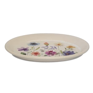 Könnte beinhalten: Ein runder, cremefarbener Keramikteller mit einem bunten Blumenmuster in der Mitte. Das Design zeigt verschiedene Wildblumen in den Farben Violett, Blau, Orange, Gelb und Rosa, mit grünen Stängeln und Blättern, die auf die Oberfläche gemalt sind.