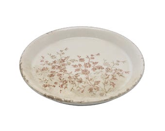 May include: Oval, off-white ceramic serving platter with a floral design in shades of brown and pink. The rim has a distressed, aged appearance. The floral pattern is concentrated in the center of the platter.