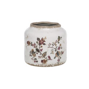Könnte beinhalten: Eine weiße Keramikvase mit einem breiten, bauchigen Körper und einem kurzen Hals. Die Oberfläche zeigt ein zartes, mehrfarbiges Blumenmuster in Rosa-, Grün- und Brauntönen. Der Rand und der Boden haben eine strukturierte, abgenutzte braune Oberfläche.