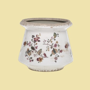 Könnte beinhalten: Ein weißer Keramiktopf mit einer abgenutzten Oberfläche und einem Blumendesign in Rosa-, Braun- und Grüntönen.