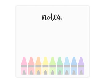 May include: A white notepad with the word "notes" written in black cursive. The bottom of the notepad has a row of eight crayons in rainbow colors.