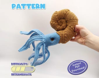 May include: Crochet amigurumi pattern for a blue and brown ammonite. The pattern is labeled "PATTERN" and "DIFFICULTY: INTERMEDIATE".