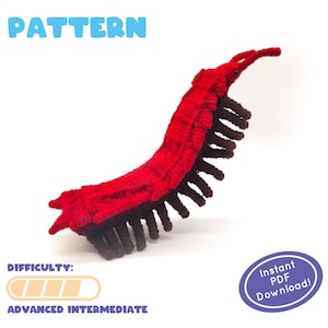 以下が含まれることがあります： 赤と茶色のムカデのアミグルミの編み図です。パターンは「PATTERN」とラベル付けされており、難易度「ADVANCED INTERMEDIATE」です。パターンは、PDFをすぐにダウンロードできます。