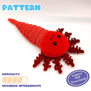 以下が含まれることがあります： 青い文字で「PATTERN」と書かれた赤いかぎ針編みの海の生き物のパターン。難易度は「上級中級」。パターンは、インスタントPDFダウンロードとして利用できます。