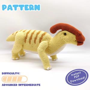 May include: Crochet pattern for a yellow and brown dinosaur with a red crest. The pattern is labeled as "Advanced Intermediate" in difficulty and includes an "Instant PDF Download" label.