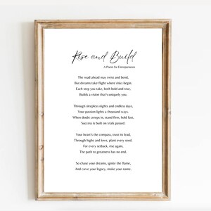 May include: A framed print with the words "Rise and Build" in elegant script, followed by a poem for entrepreneurs. The poem is printed in a classic font on a white background, framed in a light brown wooden frame.