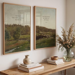 May include: Two framed landscape prints with wooden frames on a white wall. The prints depict a bridge and a river scene. One print reads "I sought the Lord, and He heard me." The other reads "And delivered me from all my fears."