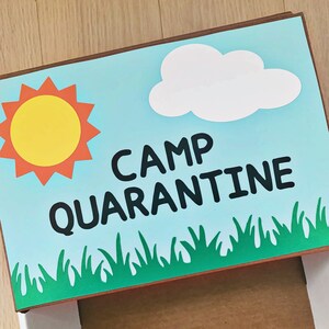 May include: A blue and white sign with the text "Camp Quarantine" in black letters. The sign also features a yellow sun and a white cloud.