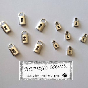 May include: A collection of silver-toned padlock charms, ideal for jewellery making or crafting projects. The charms are various sizes and feature a keyhole design. The image includes the text "Barney's Beads Set Your Creativity Free".