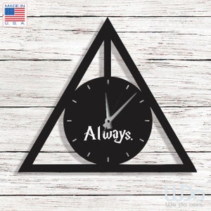 Puede incluir: Reloj de pared negro con forma de triángulo y una esfera circular. La esfera tiene agujas blancas y las palabras "Always" en una fuente estilizada.