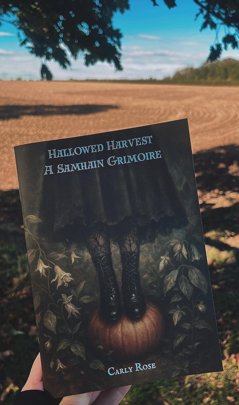 May include: A book cover with the title "Hallowed Harvest A Samhain Grimoire" features a dark illustration of a figure's legs in boots standing on a pumpkin. The author's name, Carly Rose, is at the bottom. The background is a field.