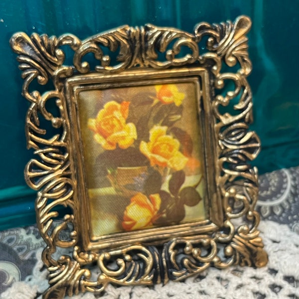 Small ornate plastic frame with floral print on silk like fabric