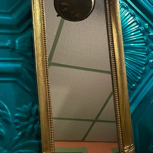 Vintage ornate gold colored plastic wall mirror- aged