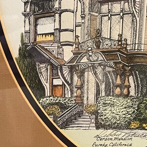 May include: A black and white drawing of the Carson Mansion in Eureka, California. The drawing is framed in a gold and black frame.