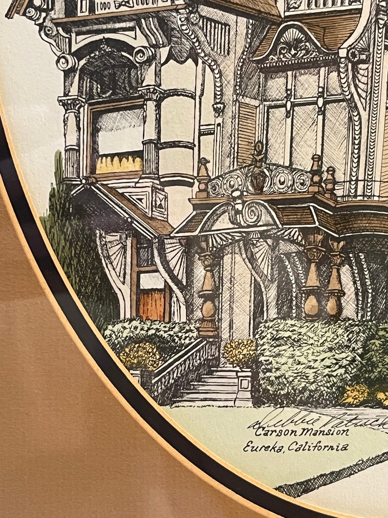 May include: A black and white drawing of the Carson Mansion in Eureka, California. The drawing is framed in a gold and black frame.