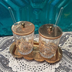 Vintage copper and glass condiment jars on tray with glass spoons