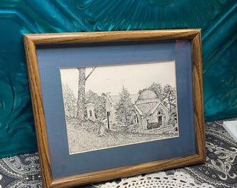 May include: A framed black and white pen and ink drawing of a stone building with a domed roof. The building is surrounded by trees and a fence. The drawing is matted in blue and framed in wood.