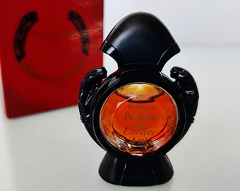 Puede incluir: Un frasco de perfume de vidrio negro con una tapa dorada y una etiqueta dorada que dice "Parfum Panthere de Cartier 4 ml".