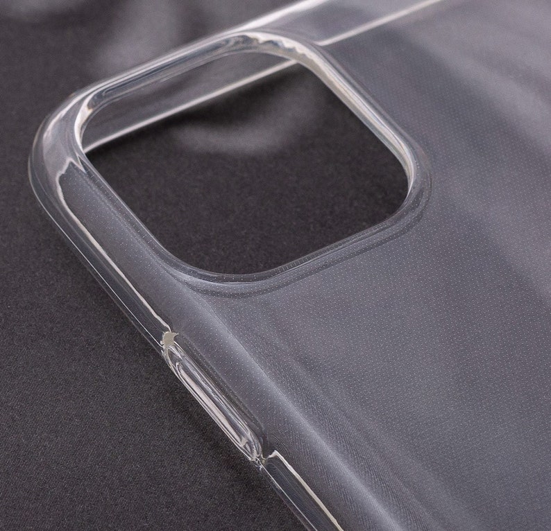 Op de afbeelding: Een transparante telefoonhoes van plastic met een textuur. De hoes is ontworpen om te passen op een smartphone met een camerabult.