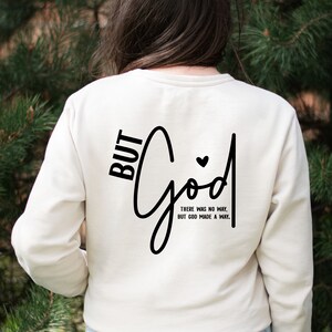 May include: White long-sleeved sweatshirt with black text that reads "BUT God THERE WAS NO WAY, BUT GOD MADE A WAY."